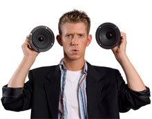 Teenaged boy holding speakers by his ears